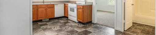 A kitchen with wooden cabinets and a checkered floor.