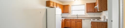 a kitchen with white appliances and wooden cabinets