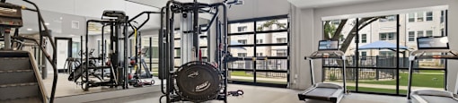 A gym with treadmills, elliptical machines, and other exercise equipment.