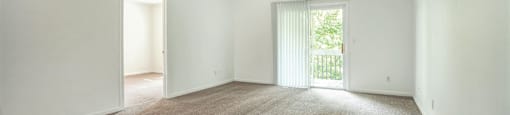 a spacious living room with white walls and carpet