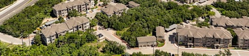 A bird's eye view of a residential area with multiple houses and a road.