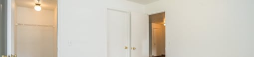 a bedroom with white walls and carpet