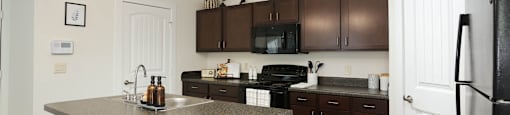 A kitchen with brown cabinets and a white refrigerator.