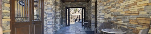 A patio with a table and chairs is surrounded by stone walls.