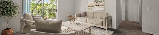 A living room with a white couch, a white chair, and a white coffee table.