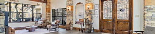 A large room with a wooden floor and a stone wall.
