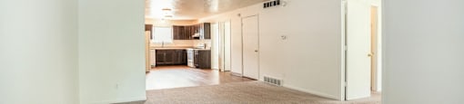 a living room with white walls and carpet