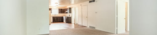 A long, empty hallway with carpeted floors and white walls.
