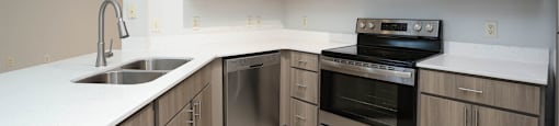 A kitchen with a sink, stove, and microwave.