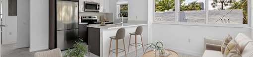A modern kitchen with a dining table set for two.