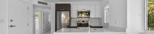 A modern kitchen with a large island and stainless steel appliances.