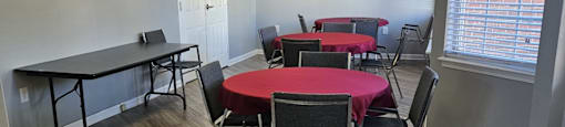 A room with tables and chairs set up for a meeting or event.