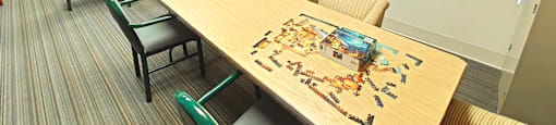 A conference room with a table surrounded by chairs and a box of Legos on the table.