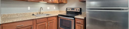 a kitchen with wood cabinets and stainless steel appliances