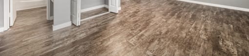 a living room with a hardwood floor and grey walls