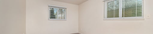 a bedroom with a carpeted floor and two windows