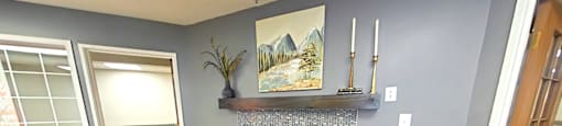 A living room with a fireplace and a painting above it.
