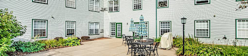 A courtyard with a table and chairs surrounded by apartment buildings.