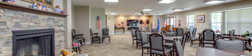Community lounge with a fireplace and chairs.