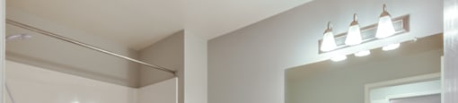 Apartment bathroom with a toilet, sink, and shower.