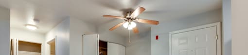 Renovated apartment with a ceiling fan and a white door.