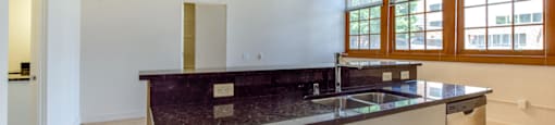 Historic apartment kitchen with a marble countertop and stainless steel appliances.