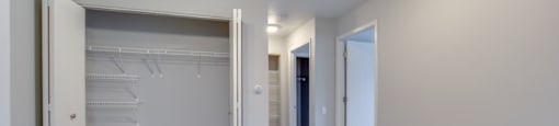Bedroom with a ceiling fan and a large closet with shelves.
