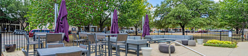 an outdoor patio with tables and chairs and a pool