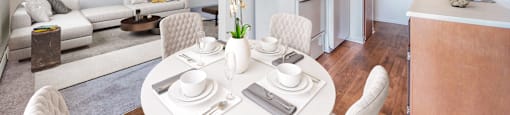 a living room and kitchen with a white table and chairs
