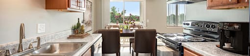 a kitchen and dining room with wooden cabinets and stainless steel appliances