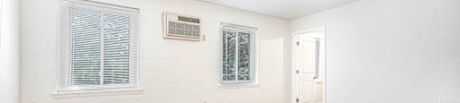 an empty living room with wood floors and white walls