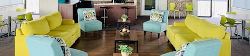 a large living room with yellow couches and blue chairs