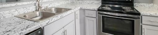 a kitchen with white cabinets and granite countertops