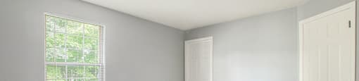 a bedroom with gray walls and a white door