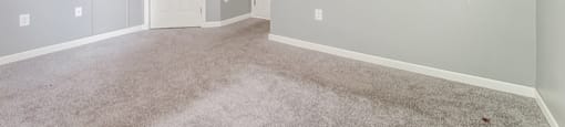 a bedroom with grey walls and carpet