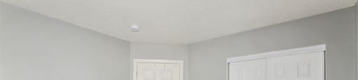 a bedroom with two doors and a carpeted floor