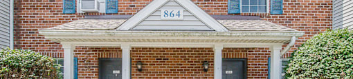 a brick building with blue shutters and a porch