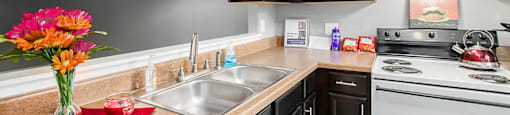 a kitchen with black cabinets and white appliances