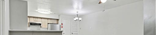 A room with a ceiling fan and wooden flooring.