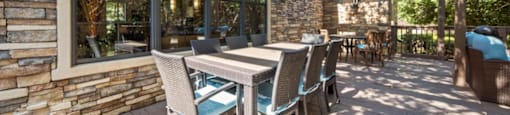a patio with a wooden table and chairs and a pergola above it