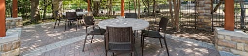 a patio with a pergola and a table and chairs