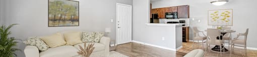 A living room with a white couch, a coffee table, and a ceiling fan.