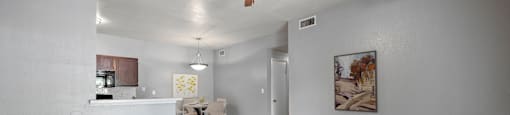 A living room with a ceiling fan and two chairs.