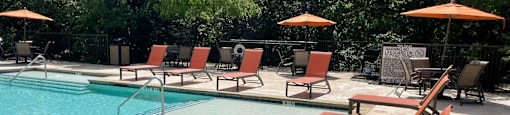 a pool with lounge chairs and umbrellas