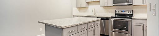 The Lofts Apartments In Grand Rapids, MI Marble Countertop Kitchen and Hardwood Floors