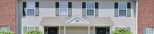 a white house with green shutters and a blue sky