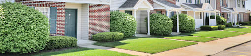 a row of houses with a sidewalk in front of them
