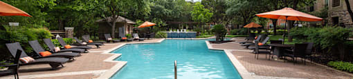 a swimming pool with lounge chairs and umbrellas