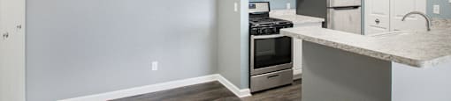 a kitchen with white cabinets and stainless steel appliances