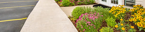 the front of a building with a flower garden in front of it